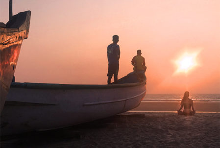 Girl meditating on beach at sunset