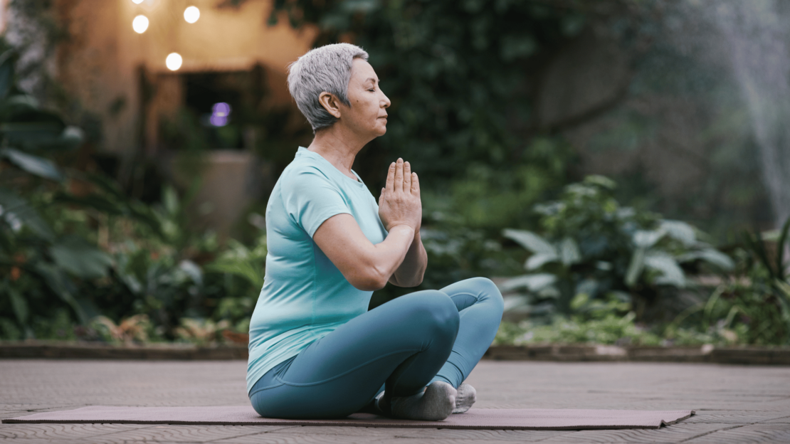 Senior woman practising gentle morning stretches—Himalaya Yoga Valley offers empowering online classes including chair yoga for seniors.