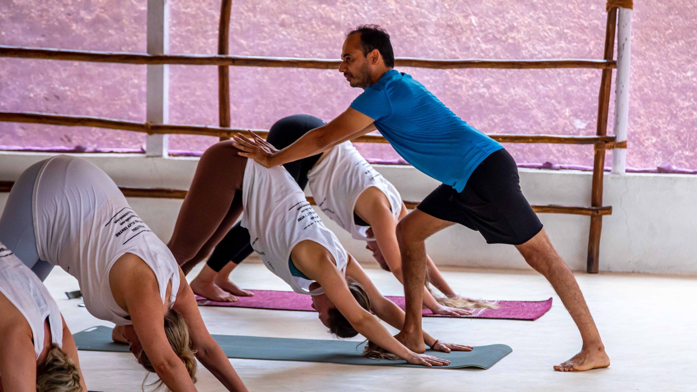A diverse group of adults practising yoga together during a yoga teacher training course.