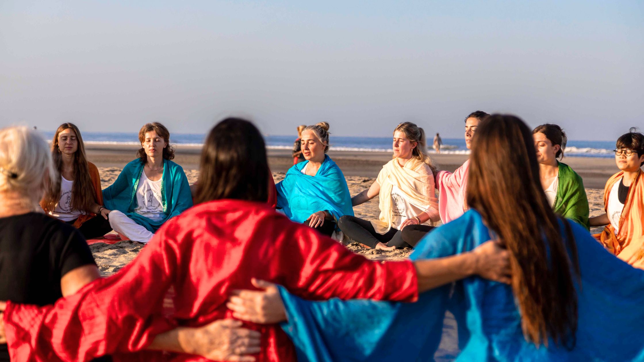 Yoga teacher guiding a meditation class in an outdoor setting, embodying the essence of yoga teacher training.