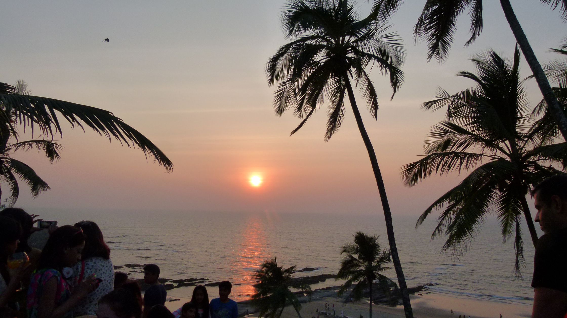 Yoga retreat group enjoying sunset together on a Goa beach after a day of practice.